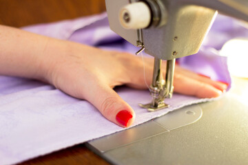 Woman taylor is working on a sewing machine