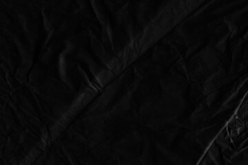 Black vintage and old looking crumpled paper background. Retro cardboard texture. Grunge paper for drawing. Ancient book page. Present wrapping.