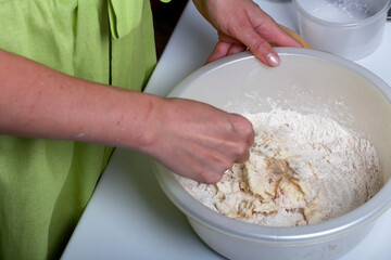 The woman is kneading the dough. Butter, sugar and flour in a bowl. Levington cake, stages of preparation.