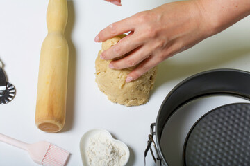 The woman is kneading the dough. Cooking tools are nearby. Levington cake, stages of preparation.