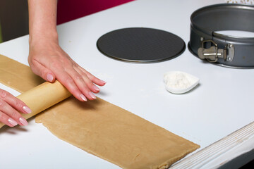 The woman rolls out the dough. Cooking tools are nearby. Levington cake, stages of preparation.