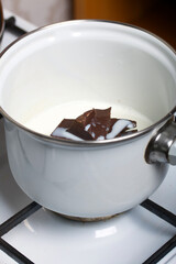 Milk chocolate in a saucepan. Levington cake, stages of preparation.