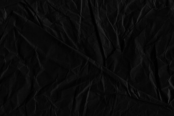 Black vintage and old looking crumpled paper background. Retro cardboard texture. Grunge paper for drawing. Ancient book page. Present wrapping.