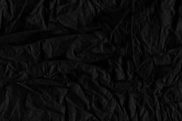 Black vintage and old looking crumpled paper background. Retro cardboard texture. Grunge paper for drawing. Ancient book page. Present wrapping.