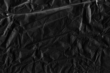 Black vintage and old looking crumpled paper background. Retro cardboard texture. Grunge paper for drawing. Ancient book page. Present wrapping.