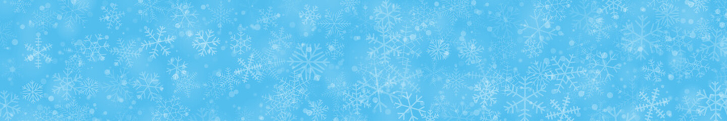 Christmas banner of snowflakes of different shapes, sizes and transparency on light blue background