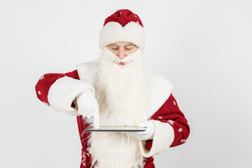 Santa Claus works with a tablet. Isolated background