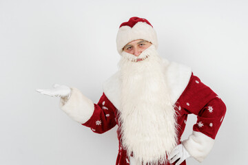 Santa Claus shows a pointing gesture, raising the palm of his hand to the top. Isolated background.