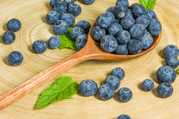 fresh blueberries in a wooden spoon over wooden table