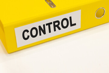 The word control on a white background with a yellow folder. Business concept