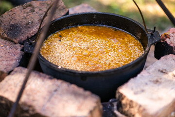 Preparation of raditional armenian pilaf in a cauldron on an open fire