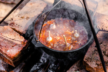 Preparation of raditional armenian pilaf in a cauldron on an open fire