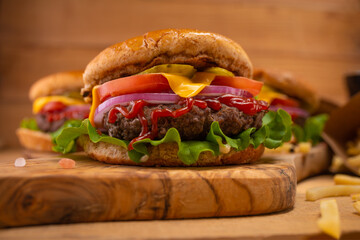 Appetizing burgers on wooden background. Fast food concept.