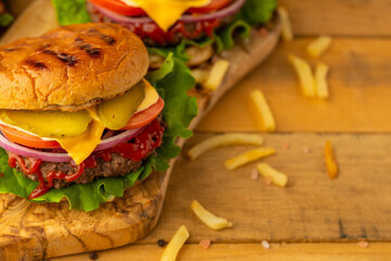 Top view of appetizing burgers on wooden background. Fast food concept.