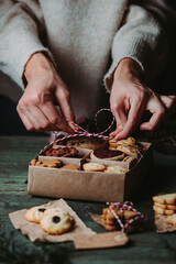 Christmas and New Year celebration traditions. Family home bakery, cooking traditional festive sweets. Woman decorating Christmas cookies and gingerbread cookies 