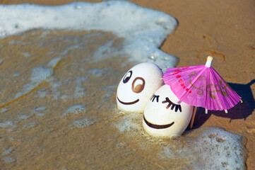 easter funny eggs under umbrella on a beach