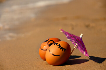 easter funny eggs under umbrella on a beach
