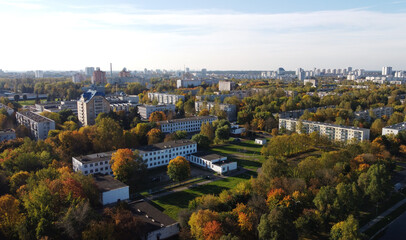 Fototapeta premium Top view of a beautiful autumn park in the city with houses