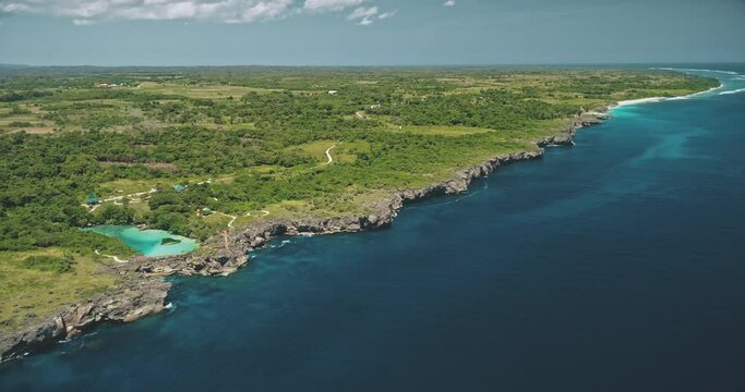 Green rock shore at ocean bay with tropical salt water lake aerial view. Nobody tropical nature landscape with turquoise lagoon at sea coast of Weekuri, Sumba island, Indonesia