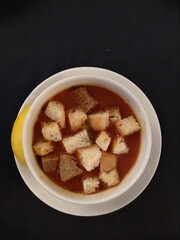 Soup from Turkish cuisine, crunchy bread and lemon with greens