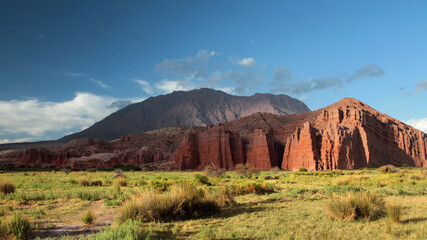 Idyllic landscape. Panorama view of the red sandstone and rock formation called The castles, in Salta, Argentina. The valley, grassland and mountains at sunset. 