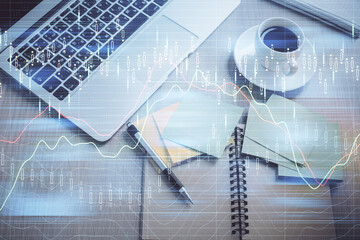 Stock market graph and top view computer on the table background. Double exposure. Concept of financial education.