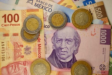 Mexican pesos bills spread randomly over a flat surface