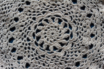 Full frame macro art abstract view of a white crocheted yarn doily texture on a dark blue background, with copy space