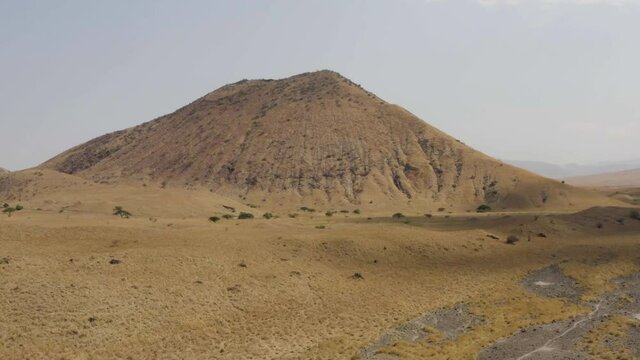 Aerial view Tanzania. A beautiful drone flight over the savannah with trees overlooking the volcano Ol Doinyo Lengai and the mountains with beautiful scenery.