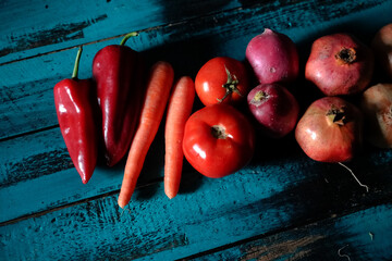 fresh red vegetables and fruits on blue wood