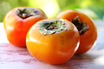 ripe persimmon fruits on wooden table