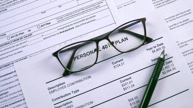 Pension savings. Glasses and pen are on the background sheet Personal 401k plan. Close-up, zoom in shot