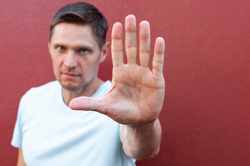 Serious-looking man raising hand up to say stop, frowning give warning, disagree with person, give...