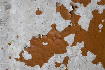 Brown peeling paint on the wall. Old concrete wall with cracked flaking paint. Weathered rough painted surface with patterns of cracks and peeling. High resolution texture for background and design.