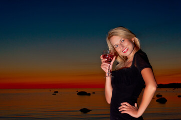Woman drinking a cocktail over looking the ocean