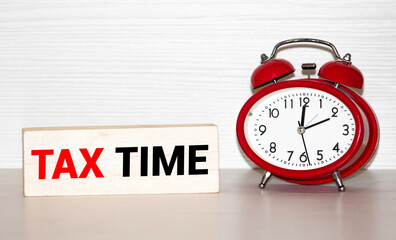 tax time on the alarm clock face. isolated on red