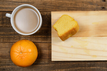 Brazilian breakfast with coffee with milk, corn cake, watermelon and orange fruit