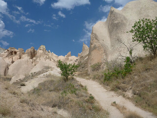 Scenic landscape view of a trail winding through the surreal landscape of Cappadocia, Turkey, on a cloudy day