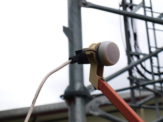 LNB or satellite TV receiver. Digital wave receiving system (KU-Band universal) of a satellite dish. On a metal structure background with a copy area. Focus closely and choose the subject.