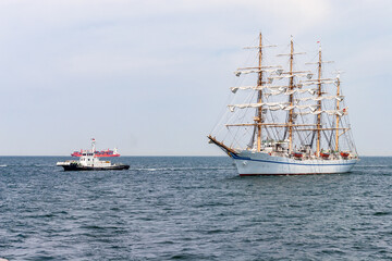 タグの先導で湾内を航行し、港に向かう帆船 © captainT