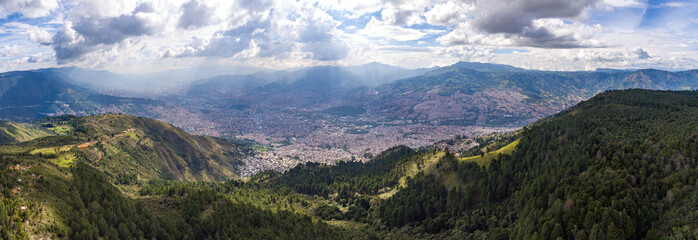 Naklejka na ściany i meble View of the City Surrounded of th Mountains in a Cloudy Day in Medellin, Antioquia / Colombia