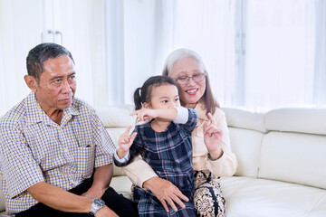 Child watching TV with her grandparents at home