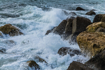 Olas de mar rompiendo contra las rocas en la playa