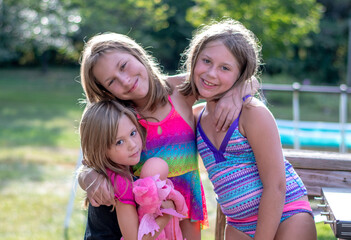 Three sisters stand  together outdoors in a sweet loving photo