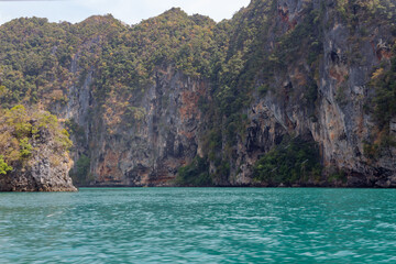 beautiful yellow gray cliffs with trees in the azure sea, Thailand