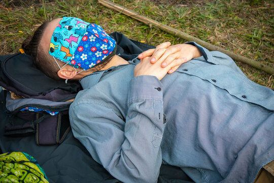 Caucasian Blond Man is Covered with Face Masks and Resting in the Middle of the Nature
