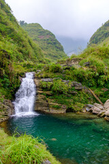 The Du Gia waterfall of Ha Giang in northern Vietnam is seen with lush green vegetation at the end of the harvest season