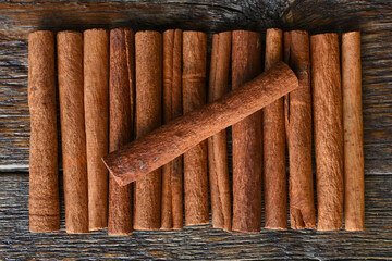 A close up image of several tasty cinnamon sticks on a dark wooden table. 