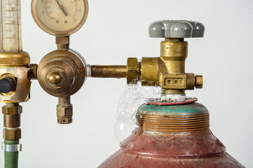 Gas cylinder for industrial welding with dial, valve and nozzle with bubble of leak