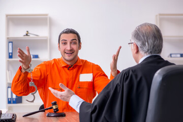 Old male judge meeting with young captive in courthouse